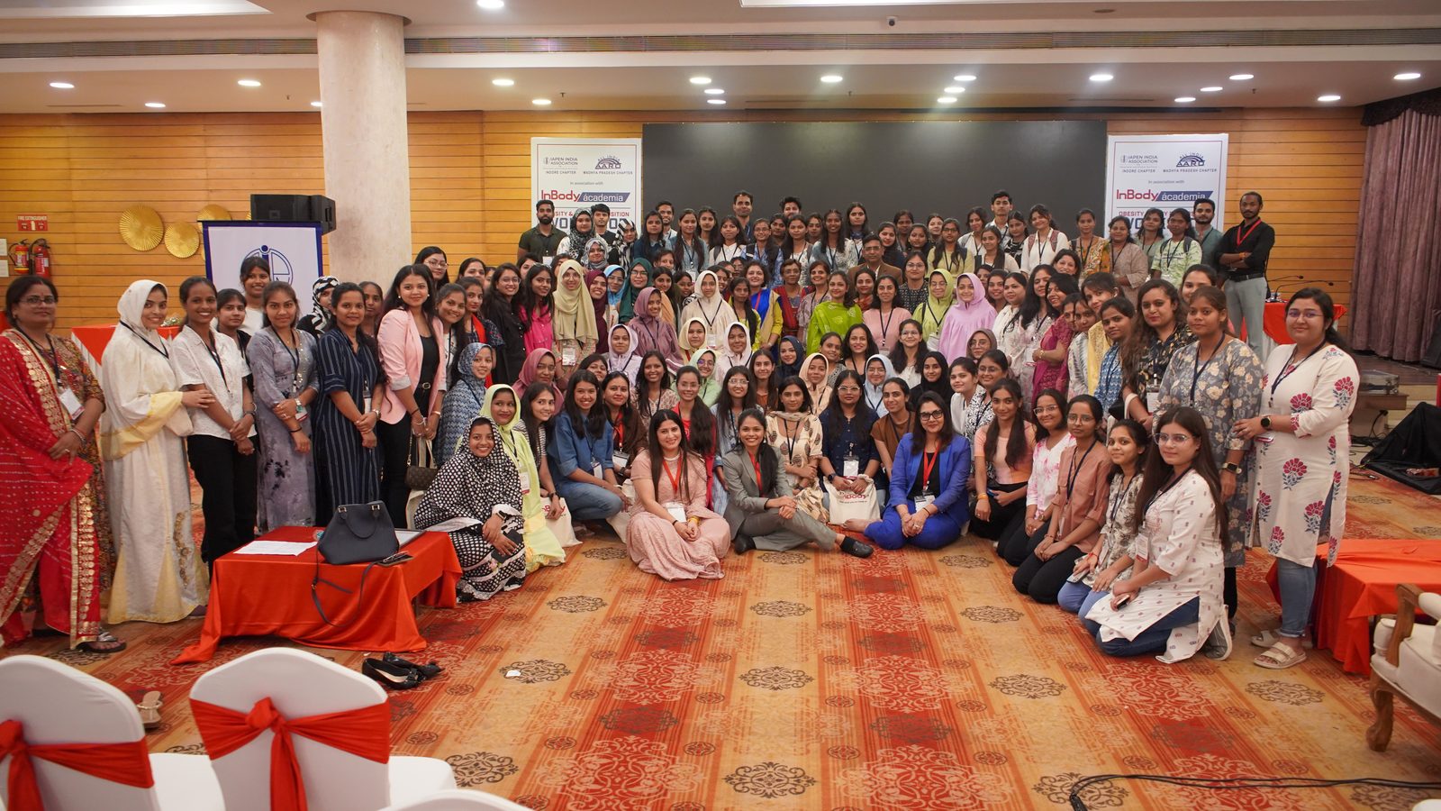 Delegates posing together in the hall at Ácademia Indore 2024.