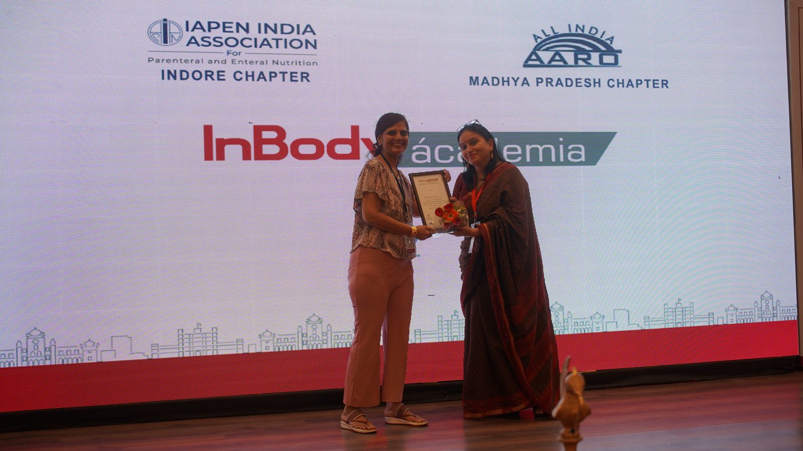 Award presentation on stage at Ácademia Indore 2024.